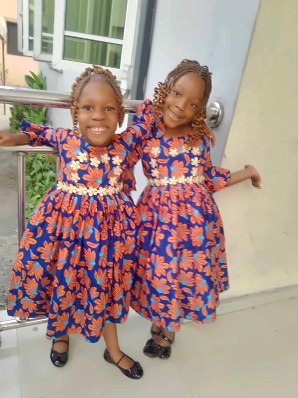 Two pupils in matching ankara dresses at the school entrance