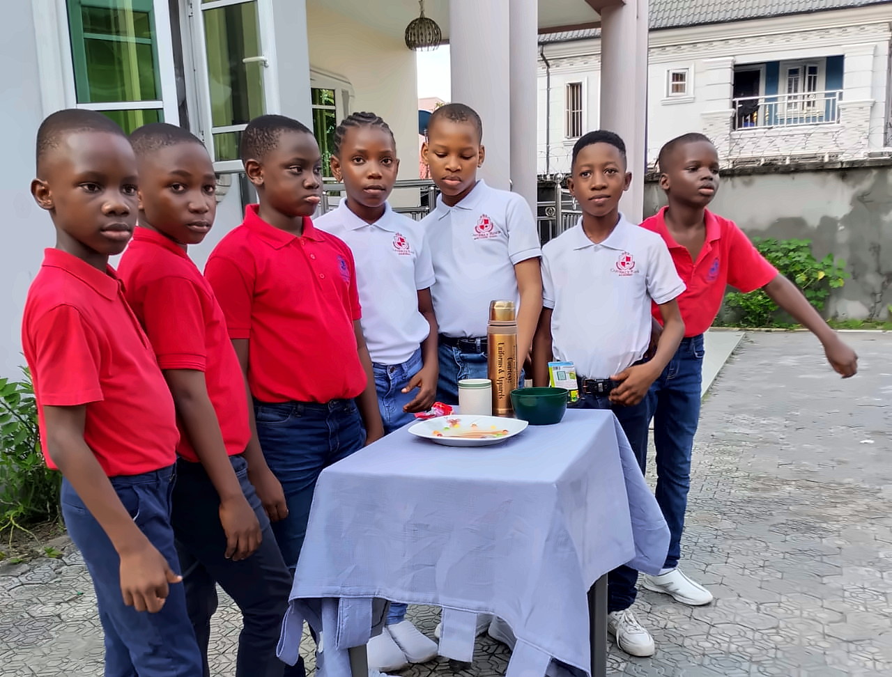 Pupils gathered around a table for a courtesy and table-manners lesson