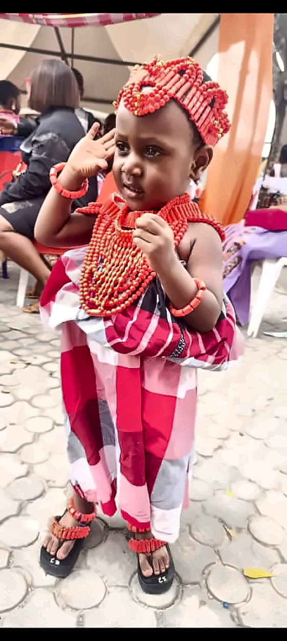 A young pupil in full coral-bead regalia and traditional wrapper on Cultural Day