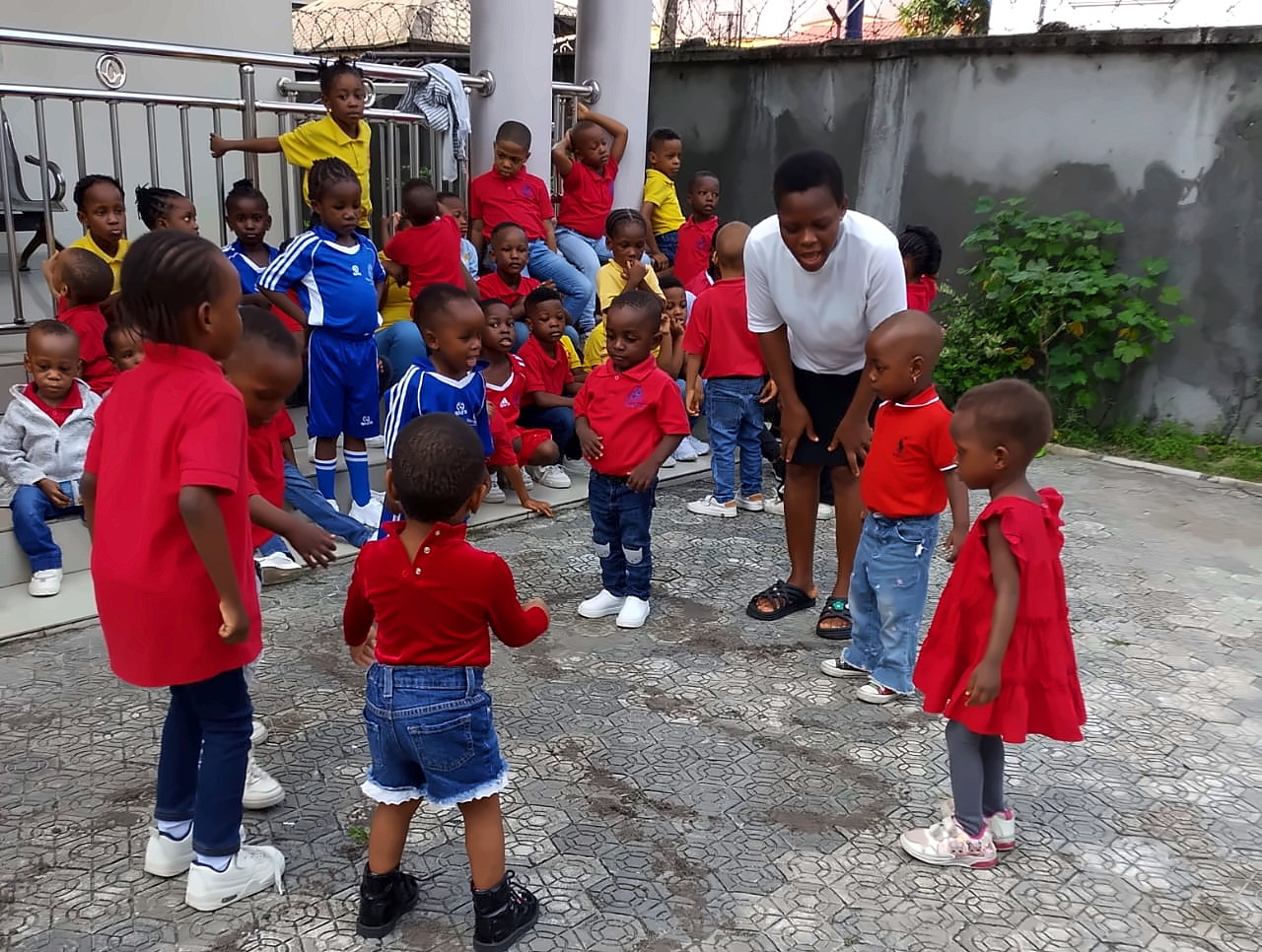 Nursery pupils and their teacher during outdoor play in the school courtyard
